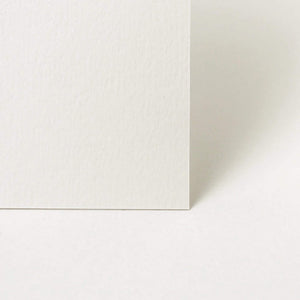Two white square tiles with a corner overlap on a light gray background