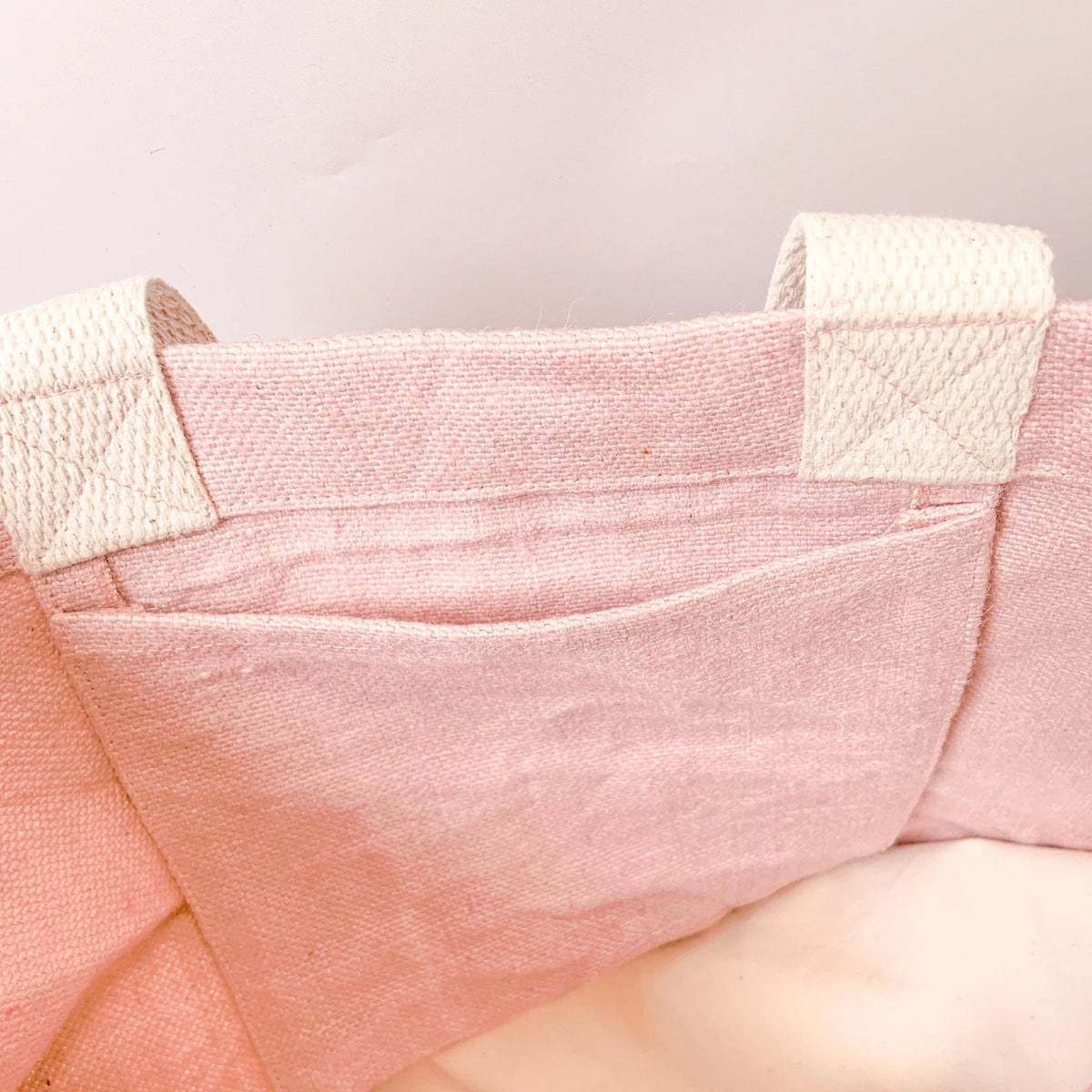 Inside detail of Amy Lucy Mama Essentials washed jute bag showing internal pocket, reinforced stitching and woven shoulder handles