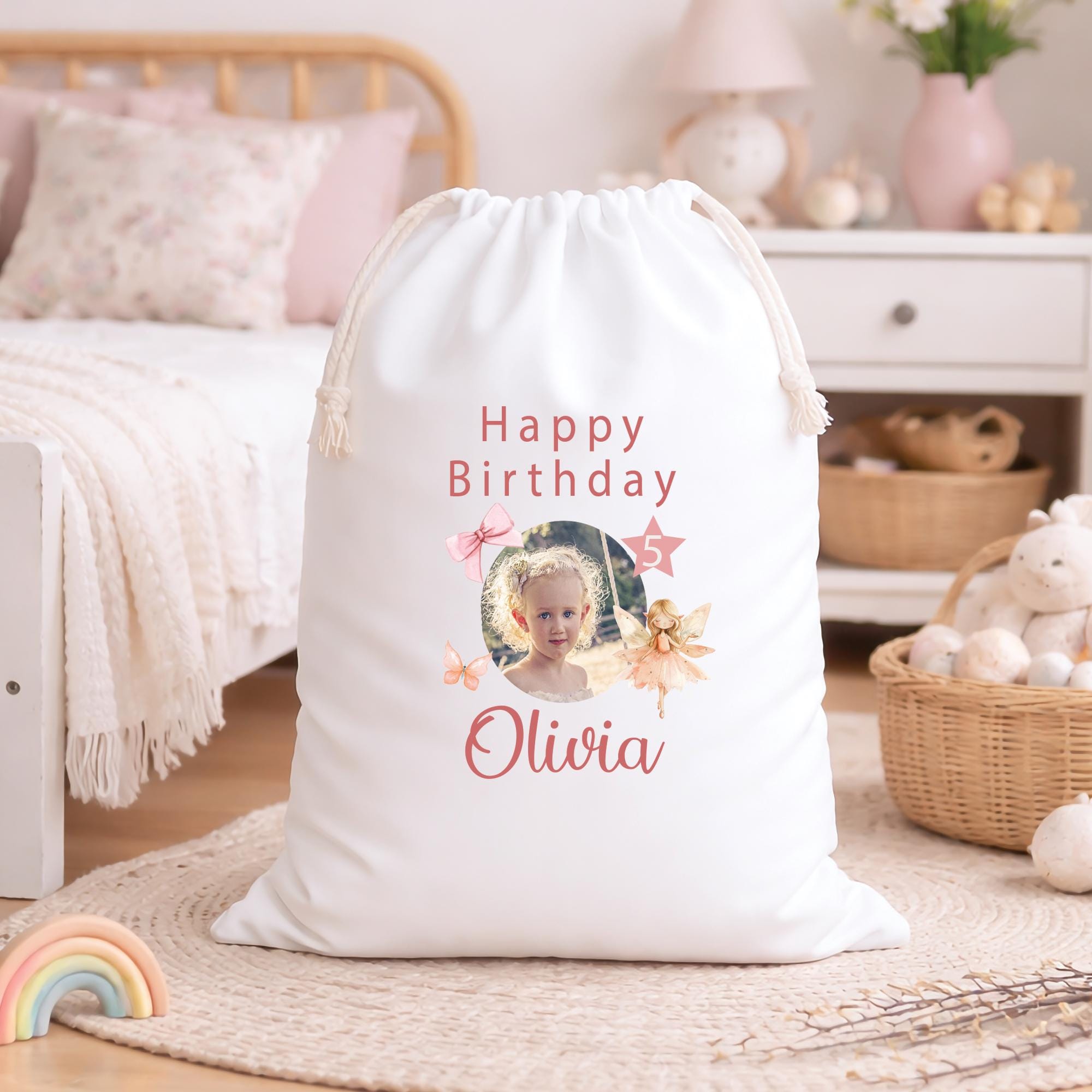 Personalized birthday gift bag with a photo of a child and 'Happy Birthday Olivia' text in a cozy room.