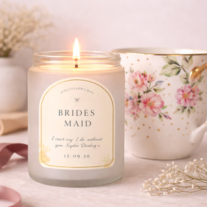 Candle labeled 'Brides Maid' with a floral teapot in the background