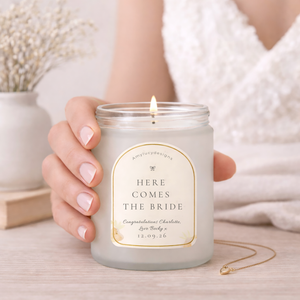 Candle labeled 'Brides Maid' held by a hand with a soft background