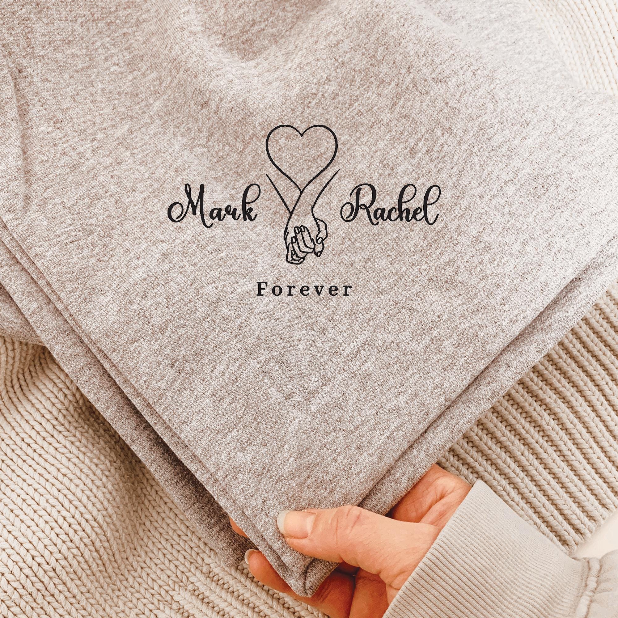 Textured blanket with 'Mark Rachel Forever' and a heart design held by a hand.