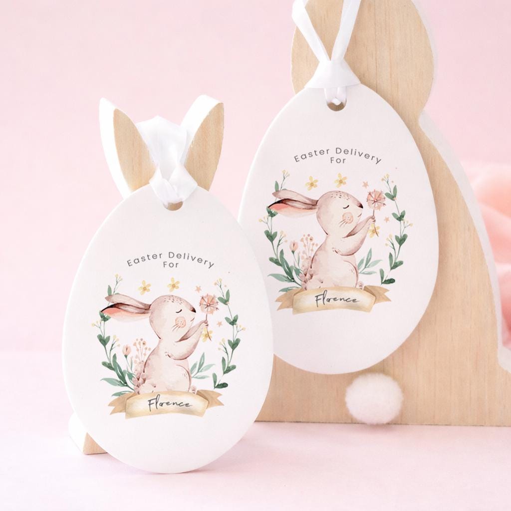Two Easter egg-shaped tags with bunny designs on a pink background