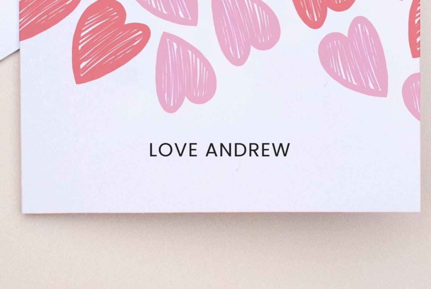 Card with pink hearts and 'LOVE ANDREW' text on a beige background