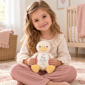 Child holding a personalised Big Sister yellow duck plush
