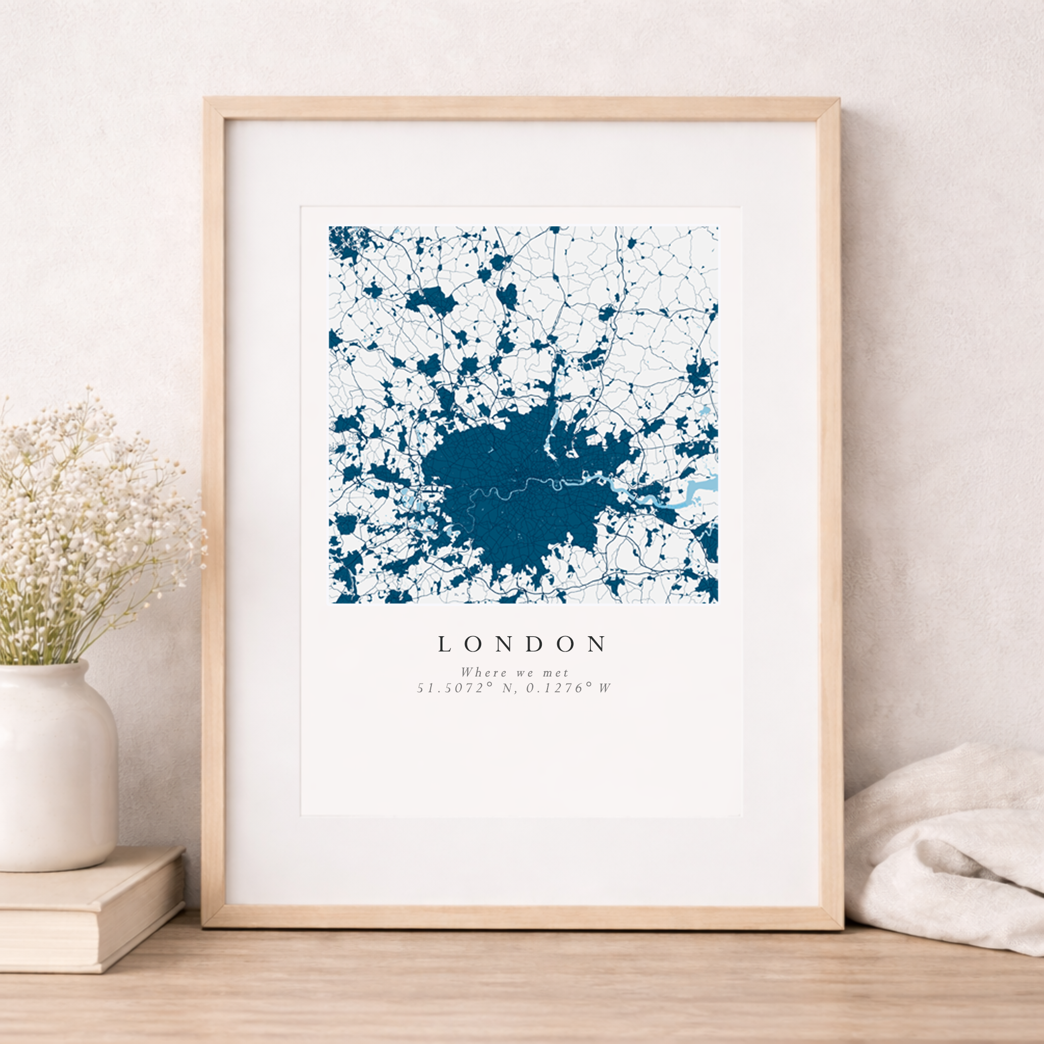 Framed map of London on a white wall with decorative items.