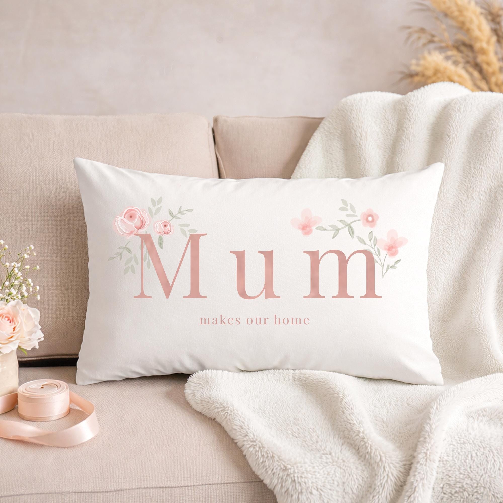 White pillow with 'Mum makes our home' text on a beige couch