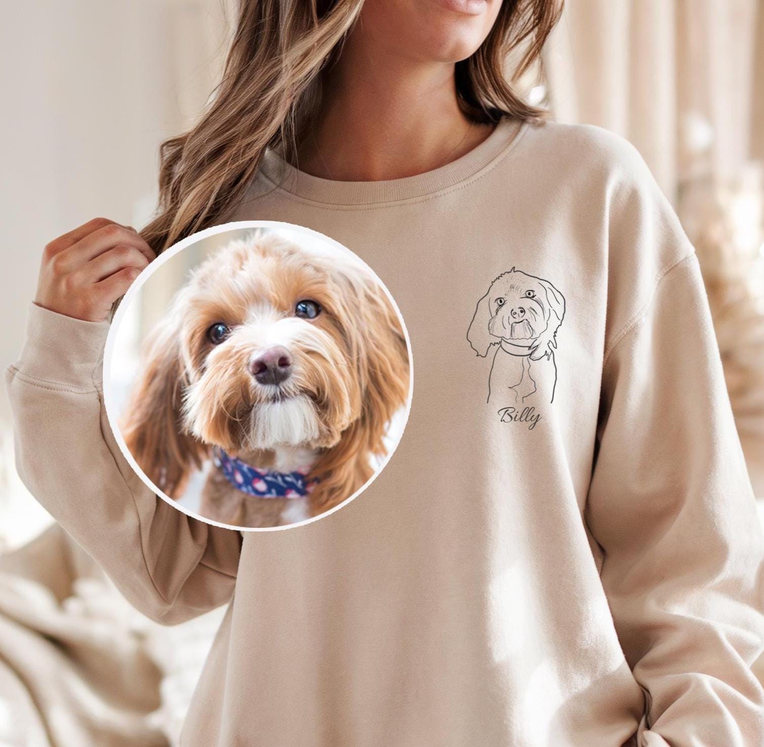 Person wearing a beige sweatshirt with a dog's name printed on it, holding a circular inset photo of a dog.