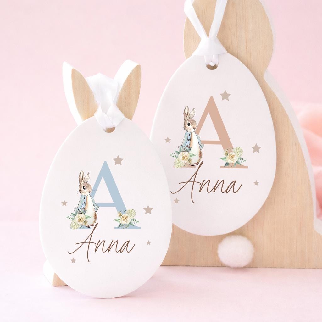 Two Easter egg-shaped tags with bunny illustrations and the name 'Anna' on a pink background.