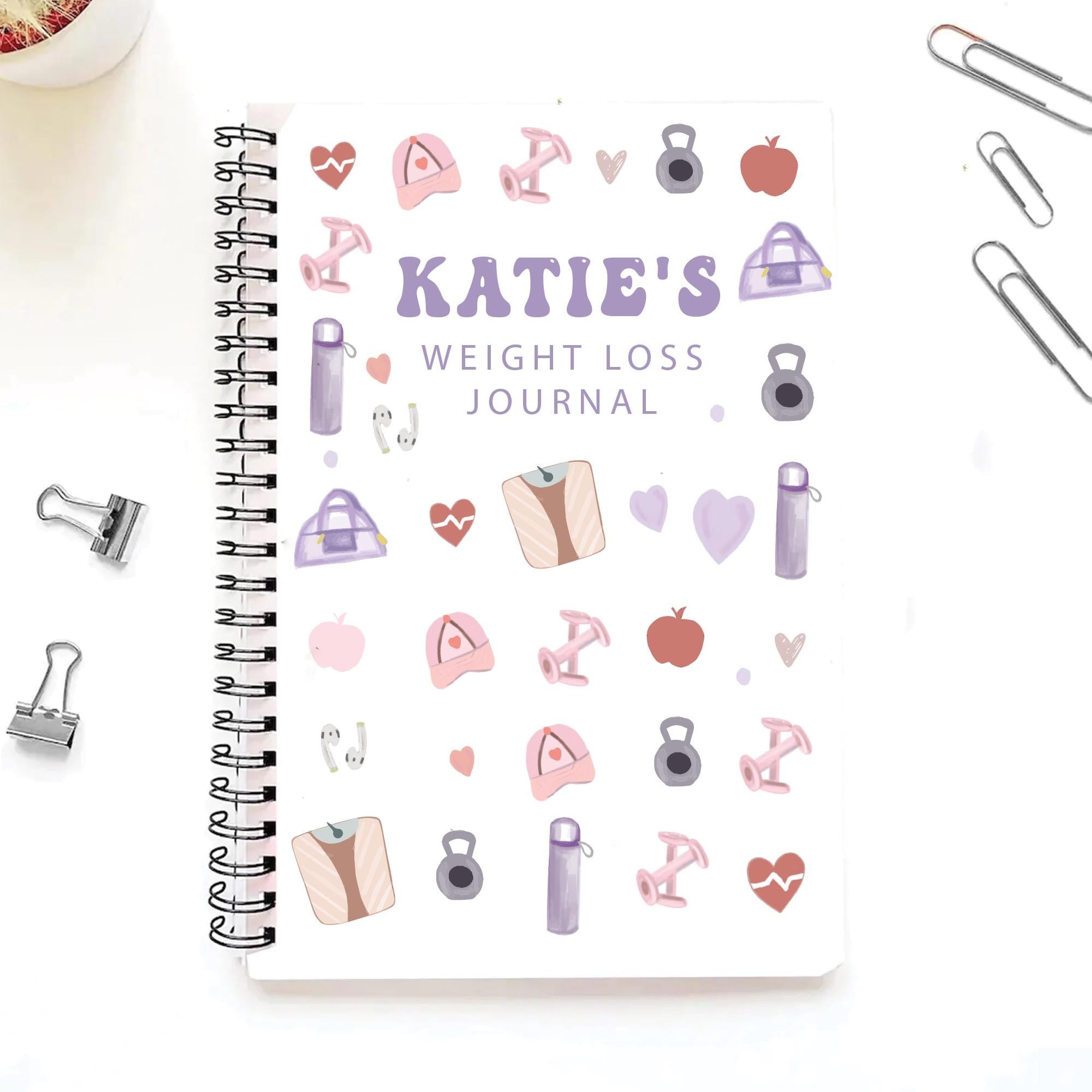 Weight loss journal with decorative elements and 'Katie's Weight Loss Journal' text on a white background.